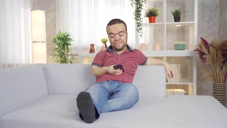 Dwarf-young-man-using-phone-at-home.